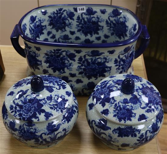 A Staffordshire style blue and white pottery footbath and a pair of lidded bowls Largest length 47cm (3)